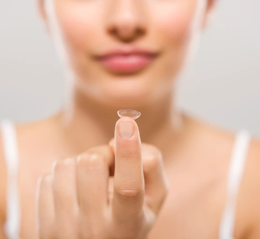 Nahaufnahme einer Frau, die eine Kontaktlinse auf der Fingerspitze hält – Kontaktlinsen-Anpassung in Dietzenbach.